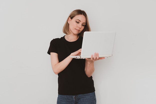 Portret Uroczej Europejskiej Kobiety W Zwykłych Ubraniach, Trzymającej Laptopa W Dłoniach I Wideorozmów Izolowanych Na Białym Tle