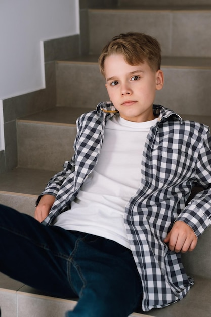 Portret uroczej nastolatki w zwykłych ubraniach Młody chłopak siedzi na schodach w budynku