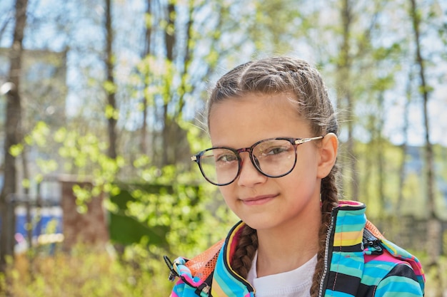 portret uroczej nastoletniej dziewczyny w okularach bawiącej się na świeżym powietrzu dziecko jest szczęśliwej wiosennej pogody