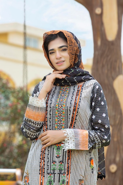 Portret uroczej pakistańskiej dziewczyny w sukience Desi i pokrytej głowie z Dupattą na zdjęcie mody