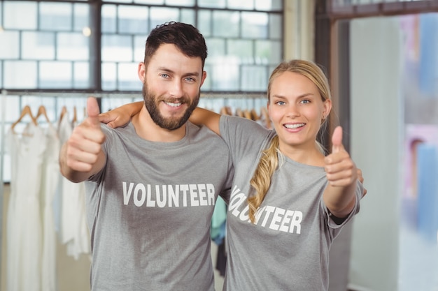 Portret Uśmiecha Się Wolontariuszi Daje Aprobatom W Biurze