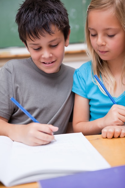 Portret uśmiechnięci ucznie pracuje wpólnie