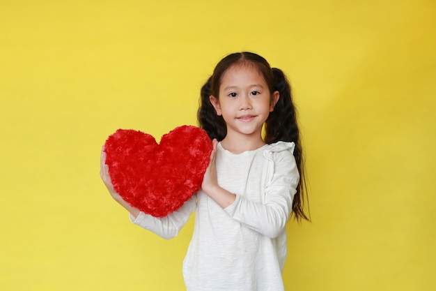 Portret uśmiechnięta Azjatycka dziewczyna trzyma czerwonego serce