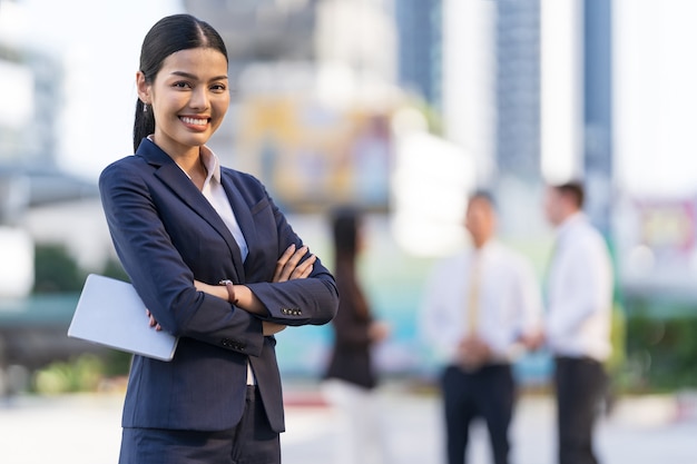 Portret uśmiechnięta bizneswoman trzyma cyfrową tabletkę i rękami skrzyżowanymi