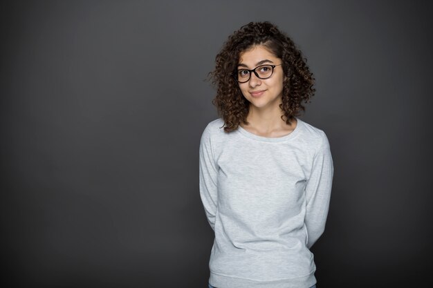 Portret Uśmiechnięta Brunetki Dziewczyna W Szkłach Na Czarnym Tle