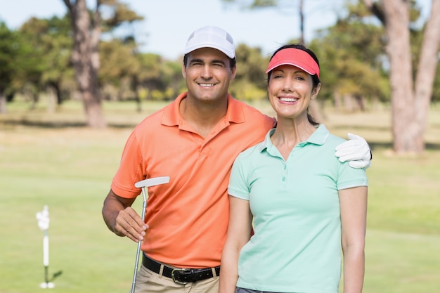 Portret uśmiechnięta golfista para z ręką wokoło