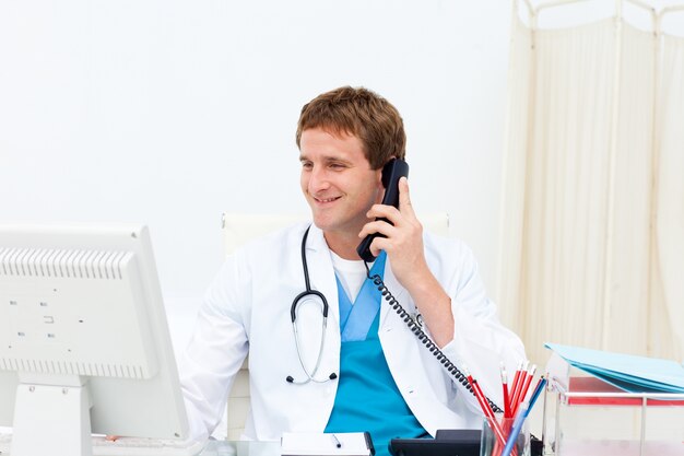 Portret uśmiechnięta lekarka na telefonie przy jego biurkiem
