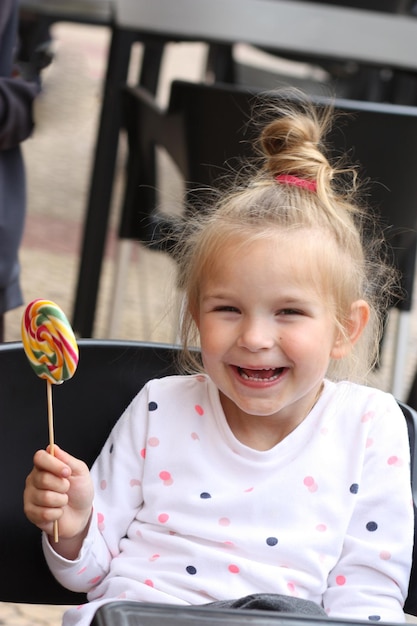Portret uśmiechnięta mała dziewczynka z cukierkiem