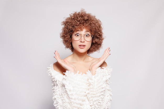 Zdjęcie portret uśmiechnięta młoda czarna kobieta. portret pięknej młodej kobiety z afro-amerykańską fryzurą afro i makijażem glamour. strzał studio. atrakcyjna dziewczyna w okularach jest zaskoczona