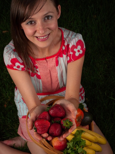 Portret uśmiechnięta młoda kobieta trzyma warzywa w koszu.