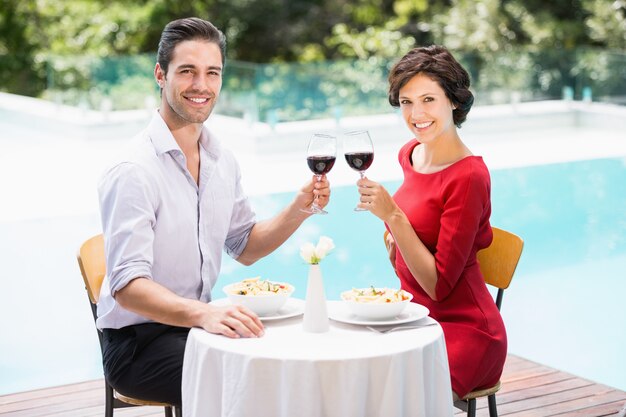 Portret uśmiechnięta para wznosi toast czerwone wino