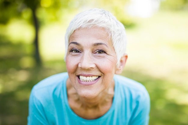 Zdjęcie portret uśmiechnięta sporty starsza kobieta w parku