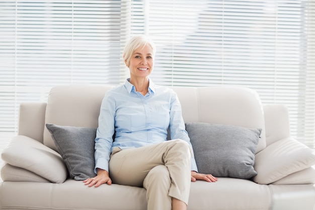 Portret uśmiechnięta starsza kobieta na kanapie