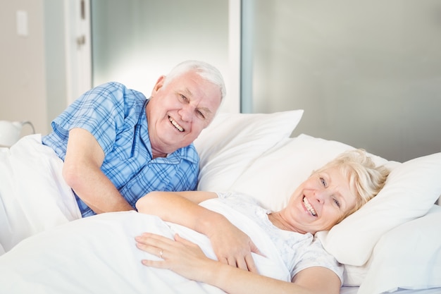 Portret uśmiechnięta starsza para relaksuje na łóżku