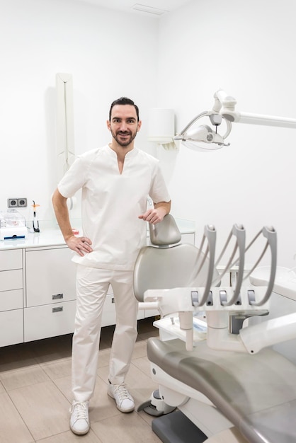 Portret uśmiechniętego dentysty w klinice
