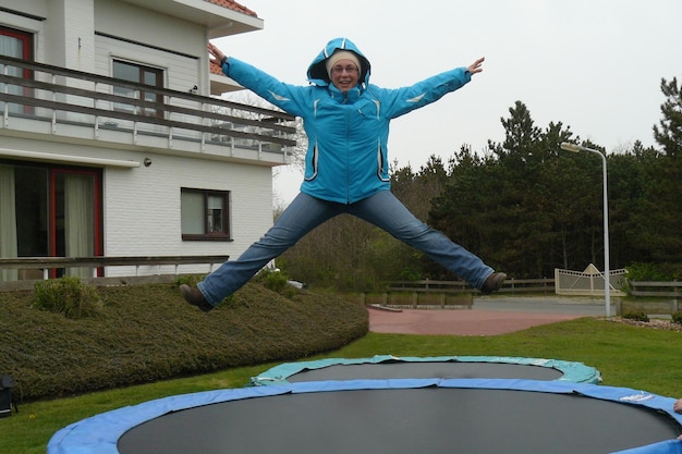 Zdjęcie portret uśmiechniętego dojrzałego mężczyzny skaczącego na trampolinie