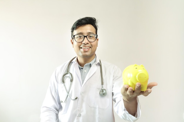 Portret uśmiechniętego lekarza trzymającego świnię na białym tle