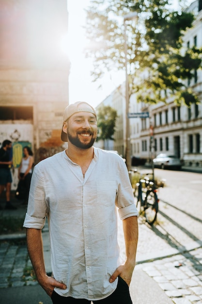 Portret uśmiechniętego mężczyzny stojącego na ulicy przed budynkami w mieście