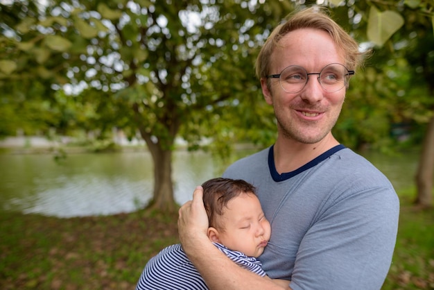 Zdjęcie portret uśmiechniętego mężczyzny z dzieckiem na świeżym powietrzu