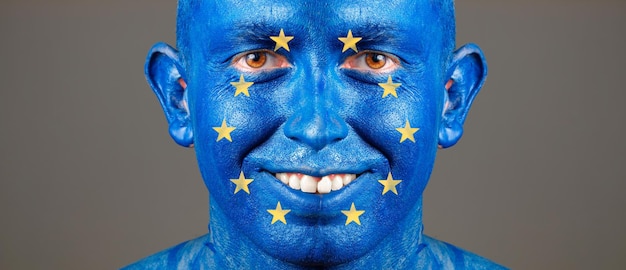 Portret uśmiechniętego mężczyzny z flagą Unii Europejskiej na szarym tle