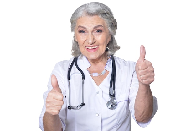 Portret uśmiechniętego starszego lekarza pokazującego aprobaty na białym tle