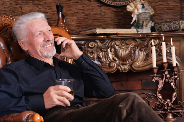 Portret uśmiechniętego starszego mężczyzny rozmawiającego przez telefon