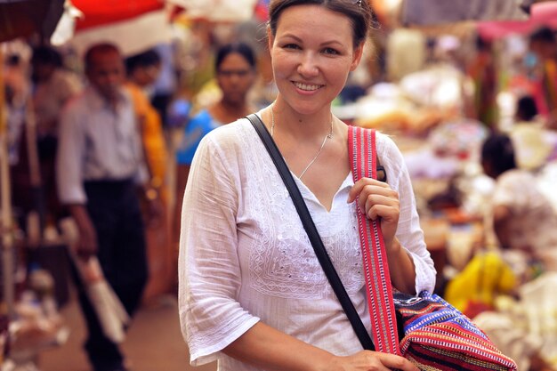 Portret uśmiechniętej atrakcyjnej młodej kobiety stojącej na ulicy