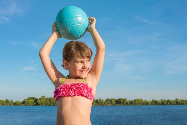 Portret Uśmiechniętej Dziewczyny Na Plaży Z Piłką W Dłoniach