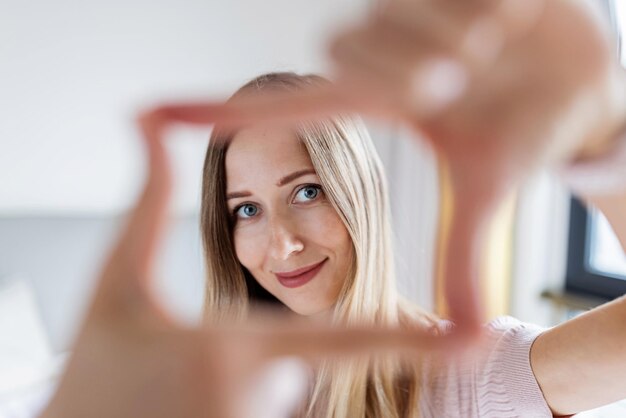 Portret uśmiechniętej kobiety patrzącej przez palce