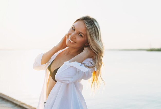 Zdjęcie portret uśmiechniętej kobiety stojącej na plaży