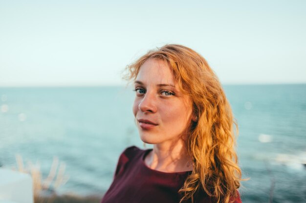 Portret uśmiechniętej kobiety stojącej na plaży