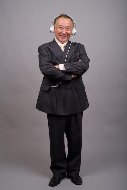 Portret uśmiechniętej kobiety stojącej na szarym tle
