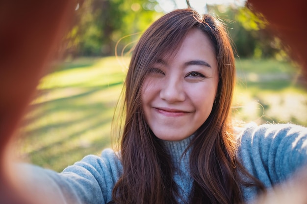 Zdjęcie portret uśmiechniętej kobiety stojącej w parku