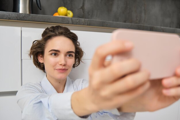 Zdjęcie portret uśmiechniętej kobiety używającej telefonu komórkowego