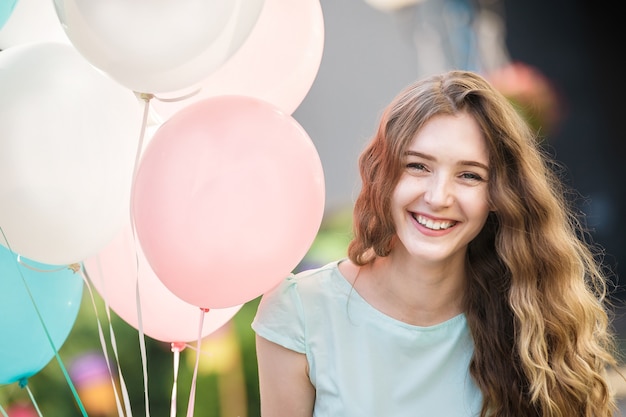 Portret Uśmiechniętej Kobiety Z Latającymi Wielokolorowymi Balonami W Mieście