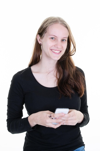 Portret uśmiechniętej młodej blondynki kaukaskiej kobiety używającej telefonu komórkowego SMS-y na białym tle