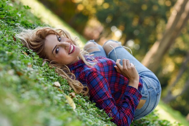 Zdjęcie portret uśmiechniętej młodej kobiety leżącej na polu