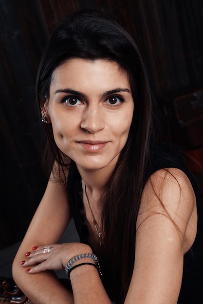 Portret uśmiechniętej młodej kobiety na czarnym tle