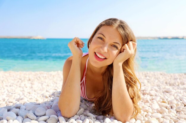 Portret uśmiechniętej młodej kobiety na plaży