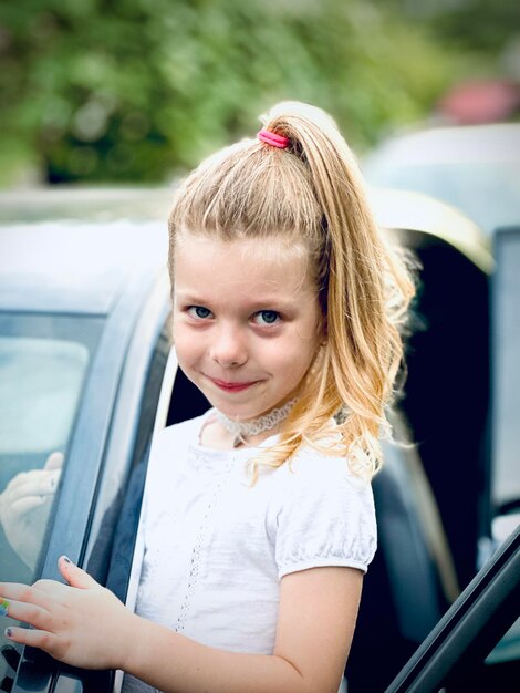 Zdjęcie portret uśmiechniętej młodej kobiety siedzącej w samochodzie