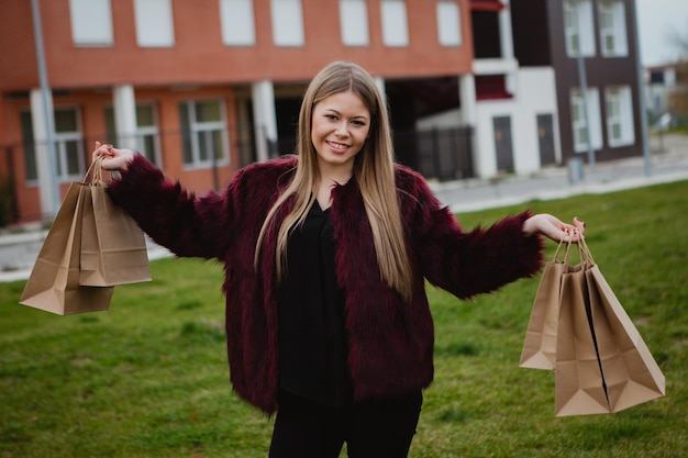 Portret uśmiechniętej młodej kobiety stojącej na zewnątrz