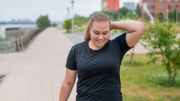 Zdjęcie portret uśmiechniętej młodej kobiety stojącej na zewnątrz