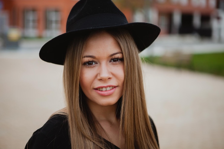Zdjęcie portret uśmiechniętej młodej kobiety w kapeluszu