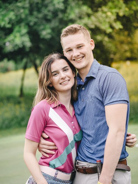 Zdjęcie portret uśmiechniętej młodej pary stojącej w parku