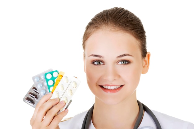 Zdjęcie portret uśmiechniętej pielęgniarki trzymającej blistery na białym tle