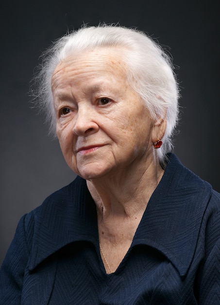Portret uśmiechniętej starej kobiety na białym tle