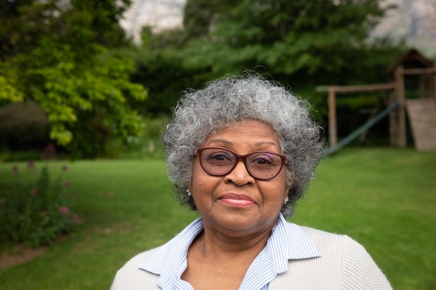 Portret uśmiechniętej starszej Afroamerykanki w ogrodzie patrzącej na kamerę. Rodzina ciesząca się czasem w domu, koncepcja stylu życia