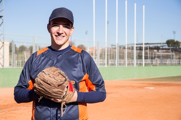Portret uśmiechnięty gracz baseballa z rękawiczką baseballową