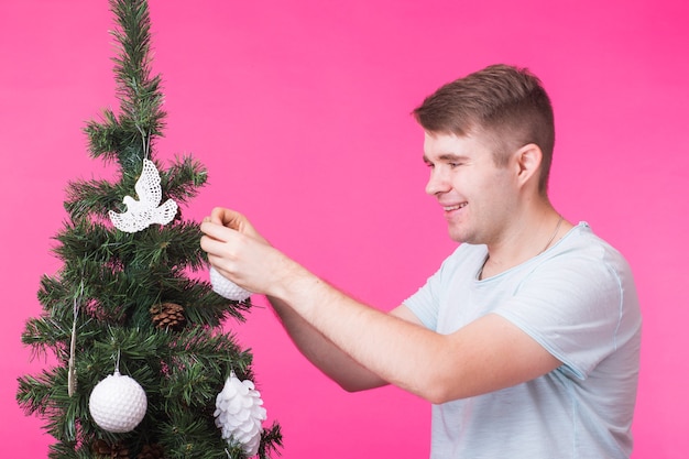 Portret uśmiechnięty mężczyzna z choinką na różowo