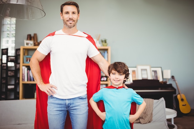 Portret uśmiechnięty ojciec i syn w superbohatera kostiumu